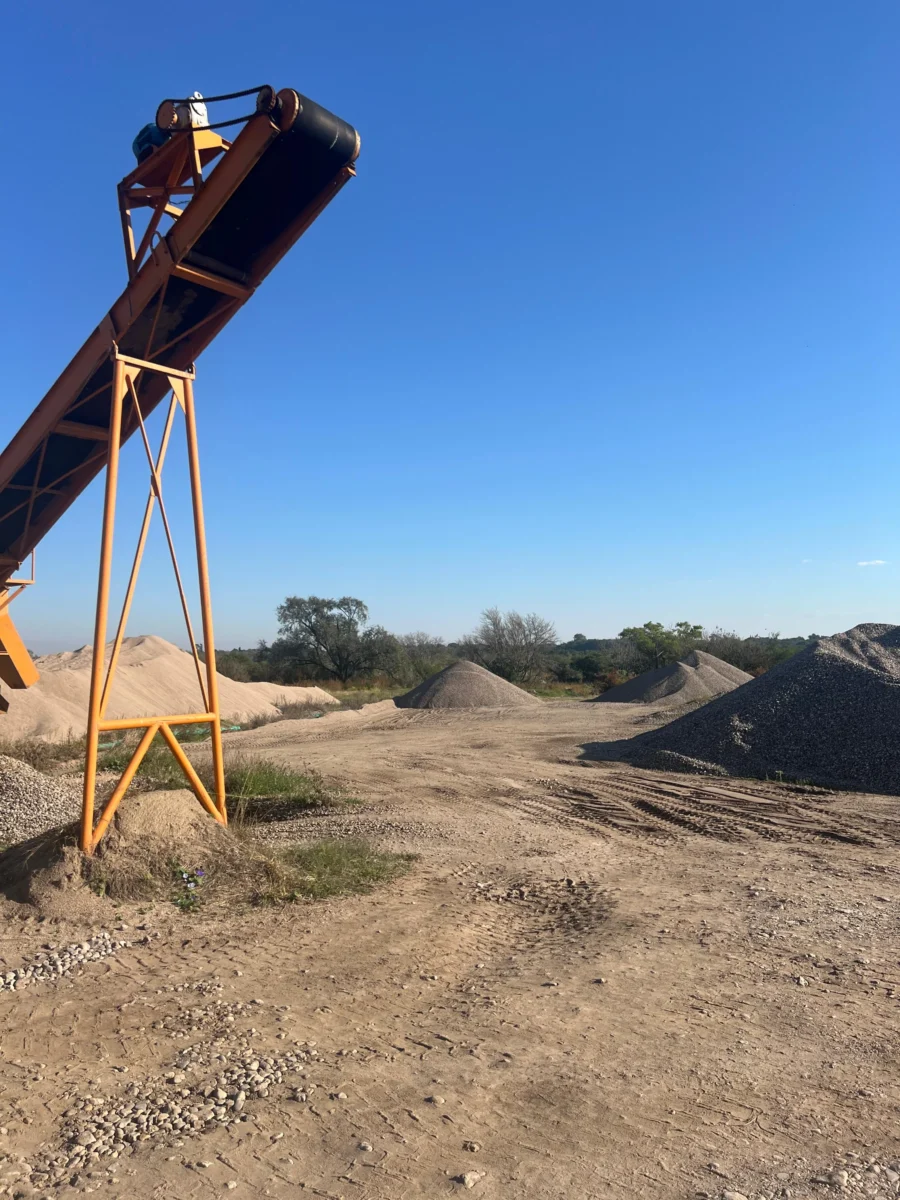 Cinta transportadora en cantera con montículos de áridos