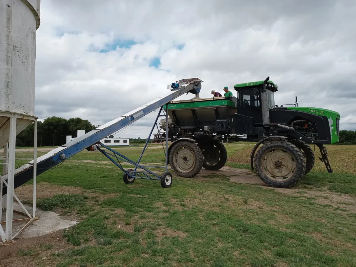 Fertilizadora agrícola cargando fertilizante desde silo en planta de Costa del Río SRL