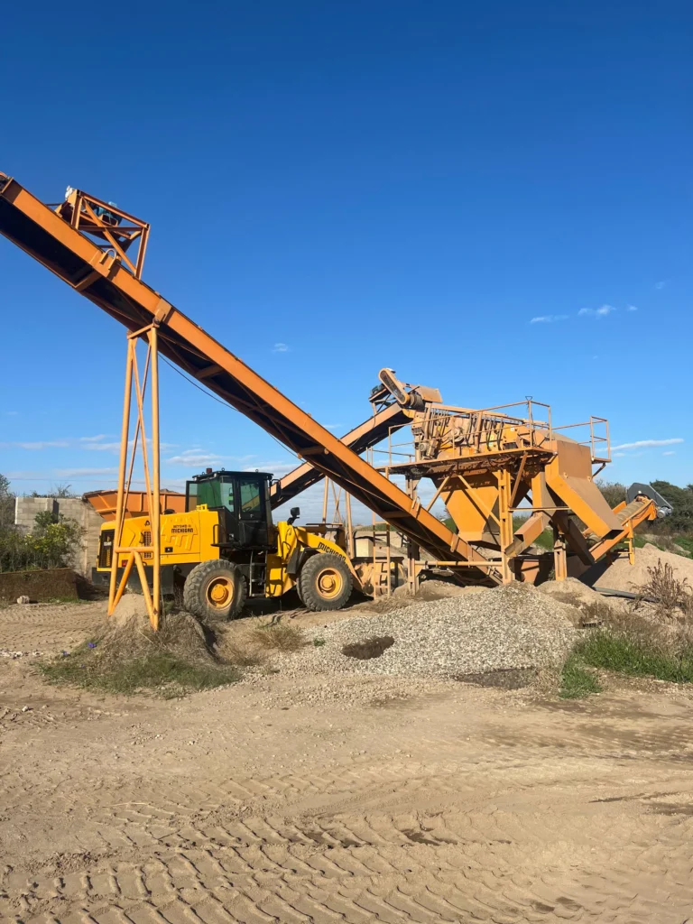Cargadora frontal junto a cinta transportadora en cantera de Costa del Río
